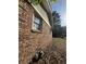 Side view of the brick house featuring a window and a green lawn at 1138 Landsdowne Dr, Charleston, SC 29412
