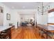 Open dining and living room area with hardwood floors, neutral decor and modern chandelier at 1153 King St, Charleston, SC 29403
