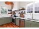 Well-lit kitchen featuring stainless steel appliances, granite countertops, and stylish sage green cabinets at 1153 King St, Charleston, SC 29403