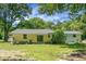 Back exterior of home with patio overlooking a large yard and mature trees at 1192 Church Of God Rd, Bonneau, SC 29431