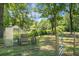 Fenced backyard featuring a greenhouse and garden at 1192 Church Of God Rd, Bonneau, SC 29431
