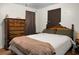 Bedroom with hardwood floors, decorative wood dresser, and a queen sized bed with neutral color blanket at 1192 Church Of God Rd, Bonneau, SC 29431