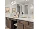 Bathroom featuring double sinks, dark cabinets, and framed artwork on the wall at 1206 Homecoming Blvd, Ravenel, SC 29470