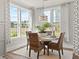 Bright dining room with a round table, wicker chairs, and a picturesque view from the large windows at 1206 Homecoming Blvd, Ravenel, SC 29470