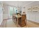 Well-lit dining room featuring an elegant chandelier, a large window, and decorative wall art at 1206 Homecoming Blvd, Ravenel, SC 29470
