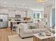 Open-concept living room and kitchen with stainless steel appliances and a comfortable sofa at 1206 Homecoming Blvd, Ravenel, SC 29470