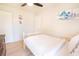 Well-lit bedroom with white bed, ceiling fan, light walls, and artwork at 1230 Hawthorne Cir, Hanahan, SC 29410