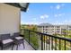 Relax on this condo balcony with comfortable seating and a view of the neighborhood buildings and blue skies at 125 Pier View St # 405, Daniel Island, SC 29492