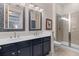 Beautiful bathroom with double sinks, navy cabinets, tiled mirrors, and a glass shower at 125 Pier View St # 405, Daniel Island, SC 29492