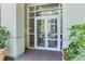 Building entrance with glass doors, brick pavers, lush plantings, and visible address number at 125 Pier View St # 405, Daniel Island, SC 29492