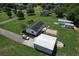 Single-Gathering home from above, showcasing a detached garage, storage sheds, and a expansive well-manicured lawn at 131 Travis Hill Rd, Moncks Corner, SC 29461