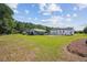 Expansive backyard featuring a well-maintained lawn, detached garage with open door, and other parking at 131 Travis Hill Rd, Moncks Corner, SC 29461