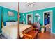 Bright bedroom featuring a four-poster bed, rich wood floors, and an ensuite bathroom at 131 Travis Hill Rd, Moncks Corner, SC 29461