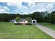 Picture perfect single-Gathering home from above, showing a white exterior, detached garage, and a sprawling manicured lawn at 131 Travis Hill Rd, Moncks Corner, SC 29461