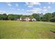 Charming single-story home featuring a sprawling green lawn, well-manicured landscaping, and a detached garage at 131 Travis Hill Rd, Moncks Corner, SC 29461