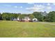 Charming single-story home featuring a sprawling green lawn, well-manicured landscaping, and a detached garage at 131 Travis Hill Rd, Moncks Corner, SC 29461