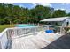 Above-ground pool with a white railing and a weathered wooden deck, set against a backdrop of lush greenery at 131 Travis Hill Rd, Moncks Corner, SC 29461