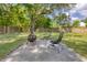 Outdoor fireplace and patio with chairs in a spacious, grassy backyard at 1317 White Dr, Charleston, SC 29407