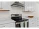 Close up of a modern stove and range hood, set against sleek white countertops at 1317 White Dr, Charleston, SC 29407