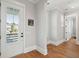 Light-filled entryway with hardwood floors and a white door with glass panel providing access to the front porch at 1502 Menhaden Ln, Mount Pleasant, SC 29466