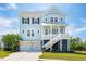 Stunning light blue two-story home featuring a staircase leading to a covered porch and a two-car garage at 1502 Menhaden Ln, Mount Pleasant, SC 29466