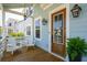 Charming porch with wooden floors, rocking chairs and a beautifully stained wood front door at 1502 Menhaden Ln, Mount Pleasant, SC 29466