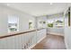 Bright hallway featuring hardwood floors, shiplap walls, and windows offering scenic neighborhood views at 1502 Menhaden Ln, Mount Pleasant, SC 29466