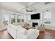 Bright living room with shiplap fireplace, large windows, and a ceiling fan for comfortable living at 1502 Menhaden Ln, Mount Pleasant, SC 29466