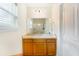 Bright bathroom features a wooden vanity with sink, a large mirror, and a view to the shower at 151 Tyger St, Summerville, SC 29485