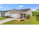 Charming tan home featuring a blue front door, well-manicured lawn, and attached garage at 151 Tyger St, Summerville, SC 29485