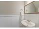 Well-lit powder room featuring a pedestal sink, decorative mirror, and wainscoting at 1511 Hopkins Ln, Mount Pleasant, SC 29466