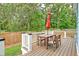 Outdoor wooden deck with table, chairs, and an umbrella for outdoor dining and entertaining at 1511 Hopkins Ln, Mount Pleasant, SC 29466