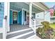 Inviting front porch with black door, rocking chair, American flag, and a beautifully landscaped garden at 1511 Hopkins Ln, Mount Pleasant, SC 29466