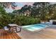 Enjoy the outdoors in this backyard featuring a refreshing in-ground pool, wooden picnic table and lush landscaping for privacy at 1511 Hopkins Ln, Mount Pleasant, SC 29466