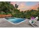 Backyard swimming pool featuring Adirondack chairs, poolside landscaping, and a wooden privacy fence at 1511 Hopkins Ln, Mount Pleasant, SC 29466