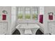 A bathroom features a free-standing tub between two vanities and three windows with shutters at 1518 Bower Ln, Johns Island, SC 29455