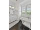 Bright bathroom with dark wood floors, white cabinets and a soaking tub by the window at 1518 Bower Ln, Johns Island, SC 29455