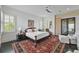 A primary bedroom features a ceiling fan, windows, dark wood floors, and a decorative rug at 1518 Bower Ln, Johns Island, SC 29455