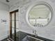 A stylish kitchen sink and door look out through a unique circular window to the marsh at 1518 Bower Ln, Johns Island, SC 29455
