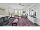 Bright living room with a large sectional, a patterned rug, and a scenic view through the windows at 1518 Bower Ln, Johns Island, SC 29455