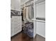 Walk-in closet with custom cabinets, shelving and dark wood floors at 1518 Bower Ln, Johns Island, SC 29455