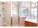 Bright bathroom featuring glass-enclosed shower, marble countertop, and large window at 155 Wentworth St # A, Charleston, SC 29401