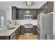 Well-lit kitchen boasts stainless steel appliances, dark wood cabinets and white counters at 157 Tyger St, Summerville, SC 29485