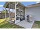 A screened porch with seating, access to the backyard and grilling area, and surrounded by green grass at 157 Tyger St, Summerville, SC 29485