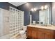 Bathroom featuring glass block shower, double vanity with granite top, and dark blue walls at 1629 Ware Bottom Ln, Mount Pleasant, SC 29464