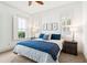 Bright bedroom featuring a bed with blue pillows and quilt, framed prints and windows with white shutters at 1629 Ware Bottom Ln, Mount Pleasant, SC 29464