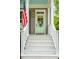 Inviting front porch stairs leading to a charming light green door, adorned with an American flag at 1629 Ware Bottom Ln, Mount Pleasant, SC 29464