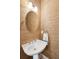 Powder room featuring an oval mirror over a white pedestal sink with textured wallpaper at 1629 Ware Bottom Ln, Mount Pleasant, SC 29464