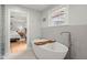 A view of a bathtub, hexagonal wall tiles, and an open door to the bedroom at 1673 Mcclain St, Charleston, SC 29407