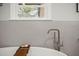 Freestanding bathtub with modern faucet and wood tray against hexagonal wall tiles at 1673 Mcclain St, Charleston, SC 29407